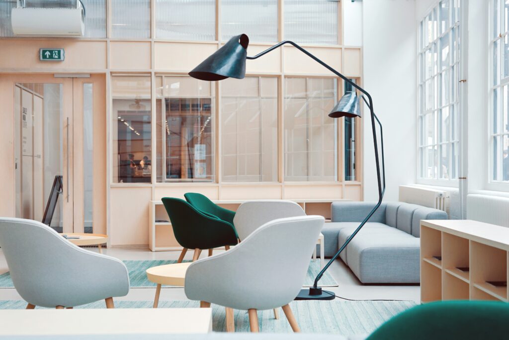 A modern office space with chairs, lamps, and a couch