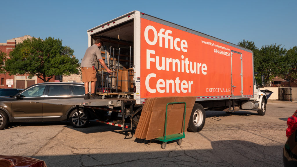 Moving truck filled with donated desks and chairs