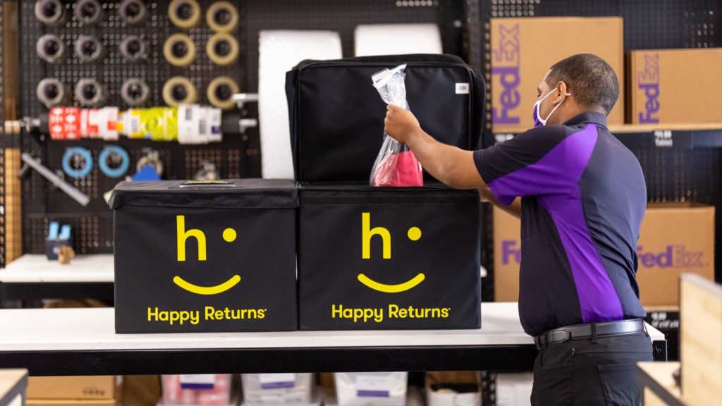 Reverse logistics worker placing items into a Happy Returns collection box